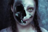 Girl with two plaits and part of a skull superimposed over her face so that only one of her eyes and her lips are visible