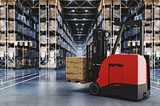 Autonomous forklift carrying pallets in a warehouse.