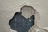 Paint chipping off the wall due to structural damping.