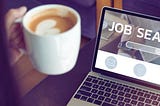 Osoba przegląda laptop z ekranem ‘JOB SEARCH’ — ilustracja do tematu na jakich portalach szukać pracy.