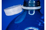 A plastic bottle with a white cap, on a blue background.