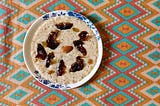 Broken wheat cooked in milk mainly with jaggery and topped with soaked nuts and dates