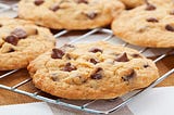 Close up shot of chocolate chip cookies sitting on a cooling rack