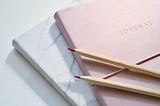 Two wooden pencils sitting across a journal