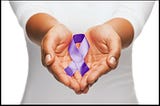 An image of someone dressed in white holding out her cupped hands, which hold a purple domestic violence ribbon.