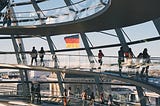 View from the top of the “Bundestag” in Berlin with people in the front, looking out over the city.
