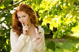 Woman, model, red hair, cream blouse, nature, trees in background, quiet, secret