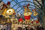 Gold bells, red baubles, silver glitter balls and curved roof of market.
