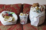 Two sacks of Christmas wrap for recycling with a tub of bits in the centre.