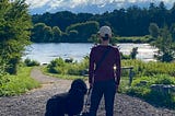 a woman with her dogs overlooking a river