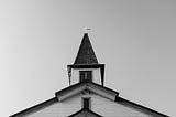 black and white image of top of Christian church