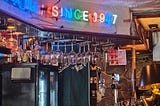 A bar table with a neon sign that writes since 1947