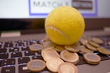 coins and a tennis ball on a computer, implying online sports betting