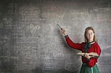 A strict female teacher pointing at either scribble or alegra on the blackboard