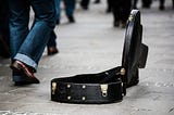 Open guitar case on the roadside