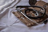 Medical tools displayed on a bed with white sheets.