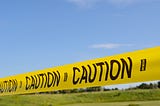 Caution tape against a bright blue sky