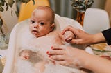 Baby being washed in baby bathtub