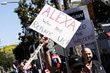 WGA striker holding up sign saying “Alexa will not replace us!”