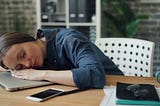 A young lady sleeping on her laptop.