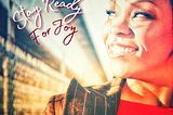 Image of African-American woman (Sonya Denyse) smiling with her face to the sun, with the words “stay ready for joy”