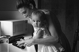 woman and baby at kitchen sink washing hands