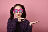 A woman with googly eyes pointing to the left. Marriage, womne, humor