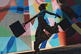 Woman skipping with shopping backs in low light against a colourful wall