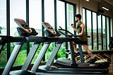 Man running on a treadmill in a gym.