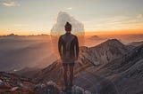 A hiker observing the sunset at the top of a big mountain