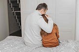 A parent holds their child and comforts them through an emotional time.