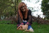 teen girl with glasses sitting in grass