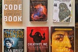 The 6 books  laid out on a table.