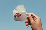 A hand holding a cup full of clouds