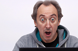 AI created picture of a middle-aged man surprised at what he sees on a computer