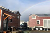 two tiny houses under a rainbow