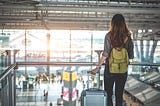 20-year-old woman waiting at airport for a flight, ready to leave home