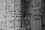 Names graffitied on a wooden wall
