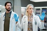 Liz holds her hands up with Theo standing behind in Transplant Season 3