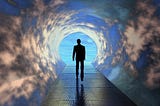 A dark silhouette of a man walks down a cloudy tunnel toward a blue sky.