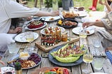 Group of people eating on a backyard. Photo by Lee Myungseong on Unsplash.