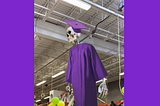 An oversize skeleton wearing a purple hat and gown.