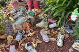Child-size workout shoes and boots in a garden, filled with succulent plantings