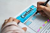 Mão feminina desenhando um wireframe com a palavra “Content” em destaque