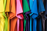 t-shirts hanging beautifully in a wardrobe in rainbow order