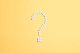 A question mark made of white circles on a yellow background.