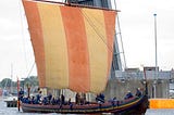Reproduction Viking Dragonship with yellow and ochre sail.