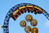 Coins with cryptocurrency logos fall from an upside down rollercoaster.