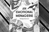A black and white photo of the book “An emotional menagerie” over a wooden surface.
