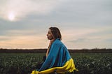 Woman with a Ukranian flag wrapped around her.